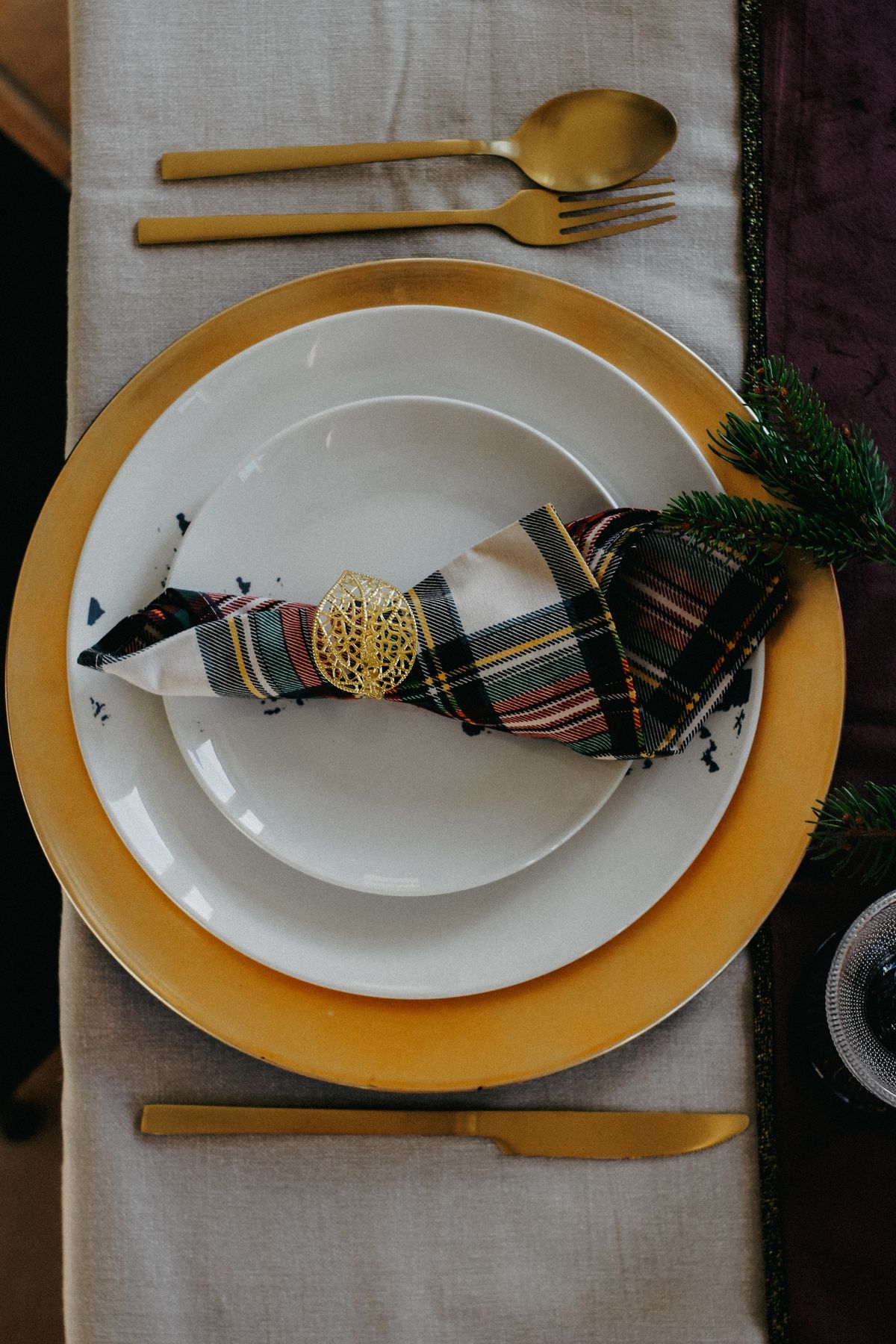 Envelope-folded plaid napkin holding a place card at a Christmas setting