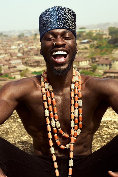 Laughing Man Wearing Traditional Necklace and Hat