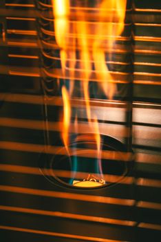 A creative close-up of colorful flames in a metal structure, evoking warmth and energy.