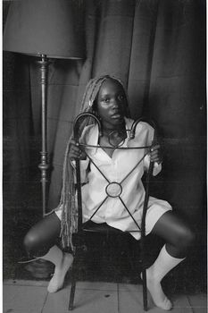 Artistic black and white photo of a woman posing with a chair