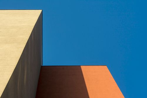 Free Abstract architectural view showcasing colorful building corners against a clear blue sky. Stock Photo