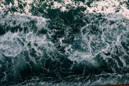 Free Aerial view of wild ocean waves crashing, showcasing natural beauty and power. Stock Photo