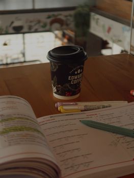 Open book with coffee cup on a desk, ideal for study or work themes.