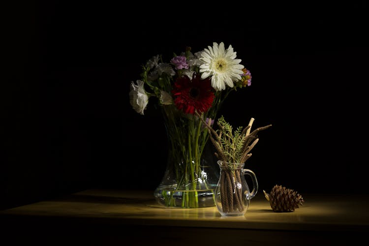 Wildflowers And Evergreen Branches In Vases In Dark