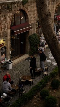 Outdoor cafe with people enjoying leisure time in an elegant, urban alleyway setting.