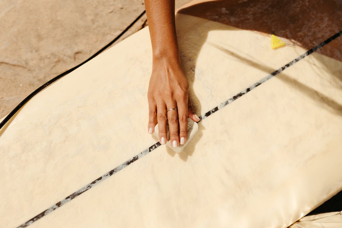 Close-up of Woman Waxing a Surfboard 