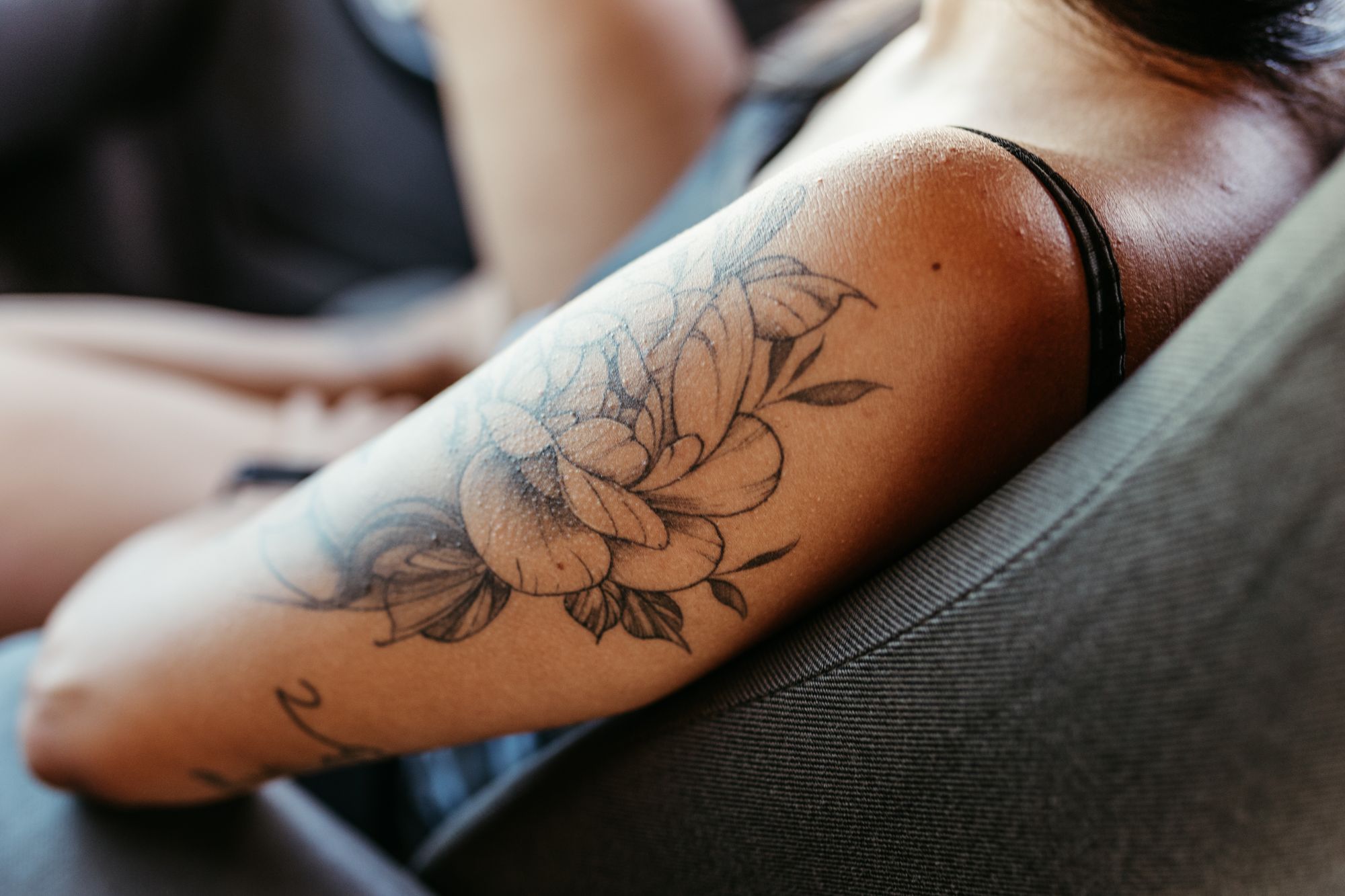Close-up of a fine-line floral tattoo on skin
