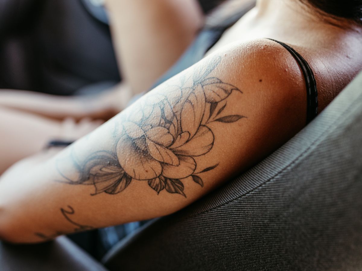 A fine-line wave tattoo wrapping around a forearm.
