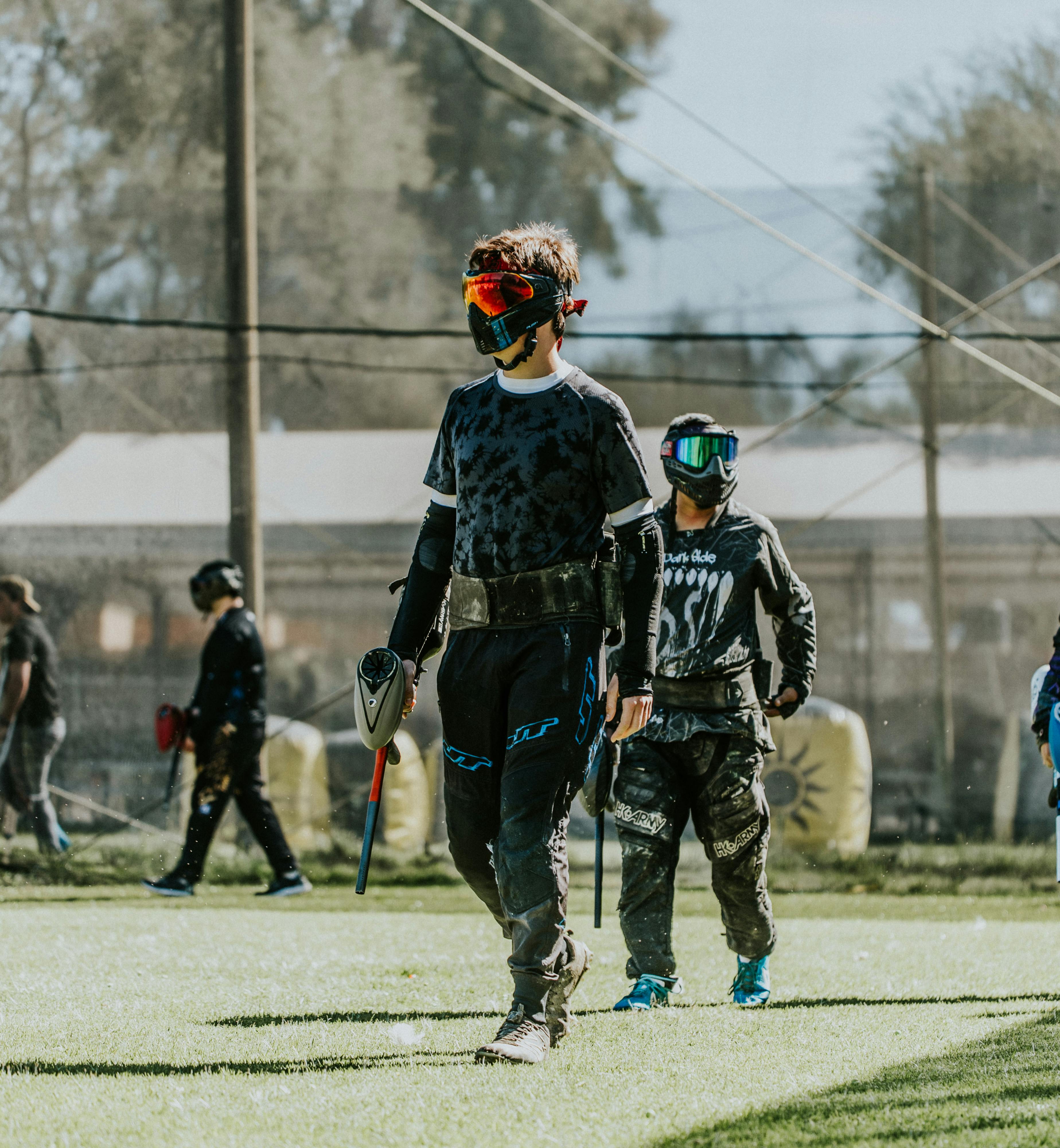 Jeunes joueurs de paintball en tenue d'action lors d'un match compétitif en extérieur. Prescription Goggle Inserts - Young paintball players in action gear during a competitive outdoor match.