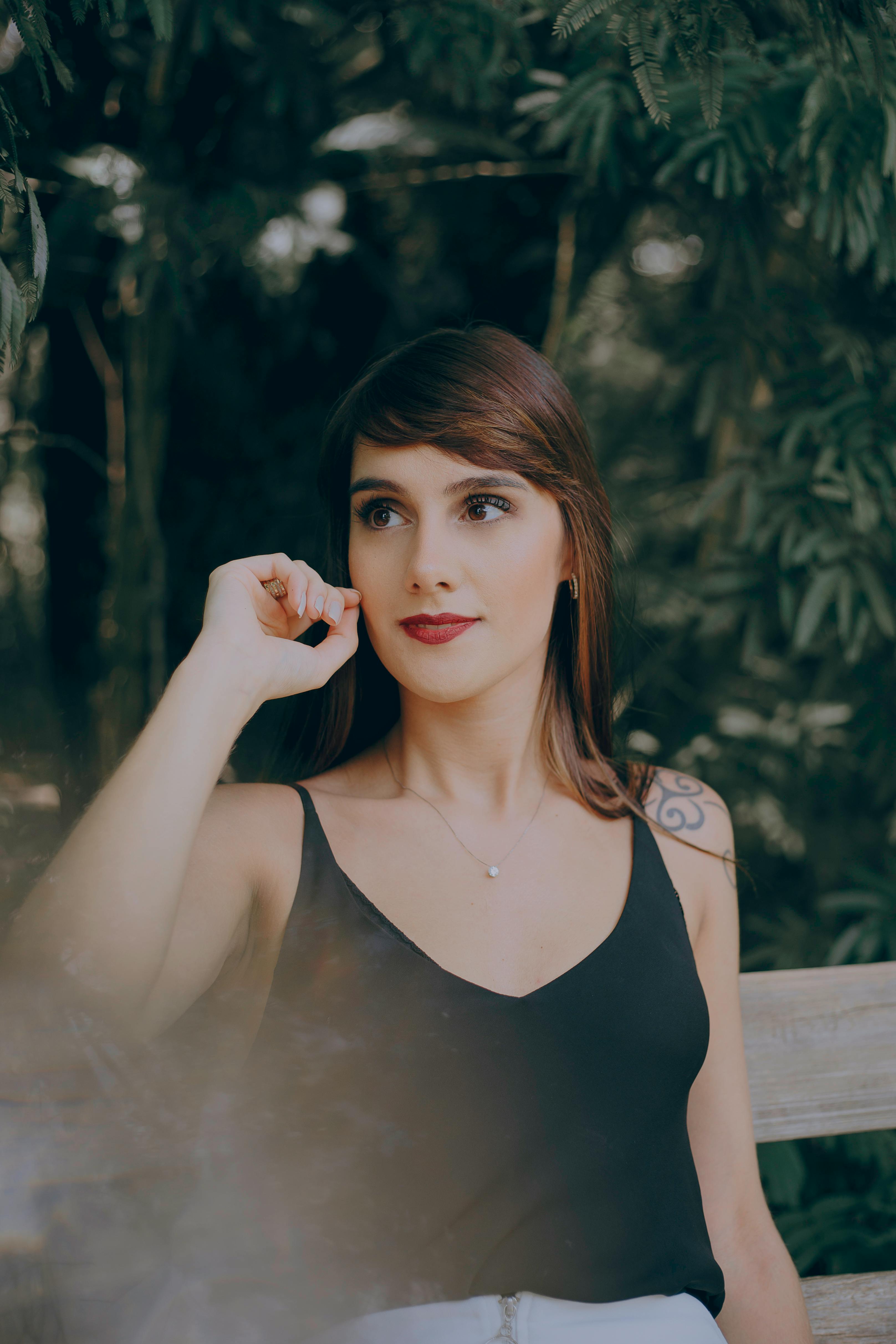 gratis Selectieve Aandacht Fotografie Van Vrouw Zittend Op Bruin Houten Bankje Stockfoto