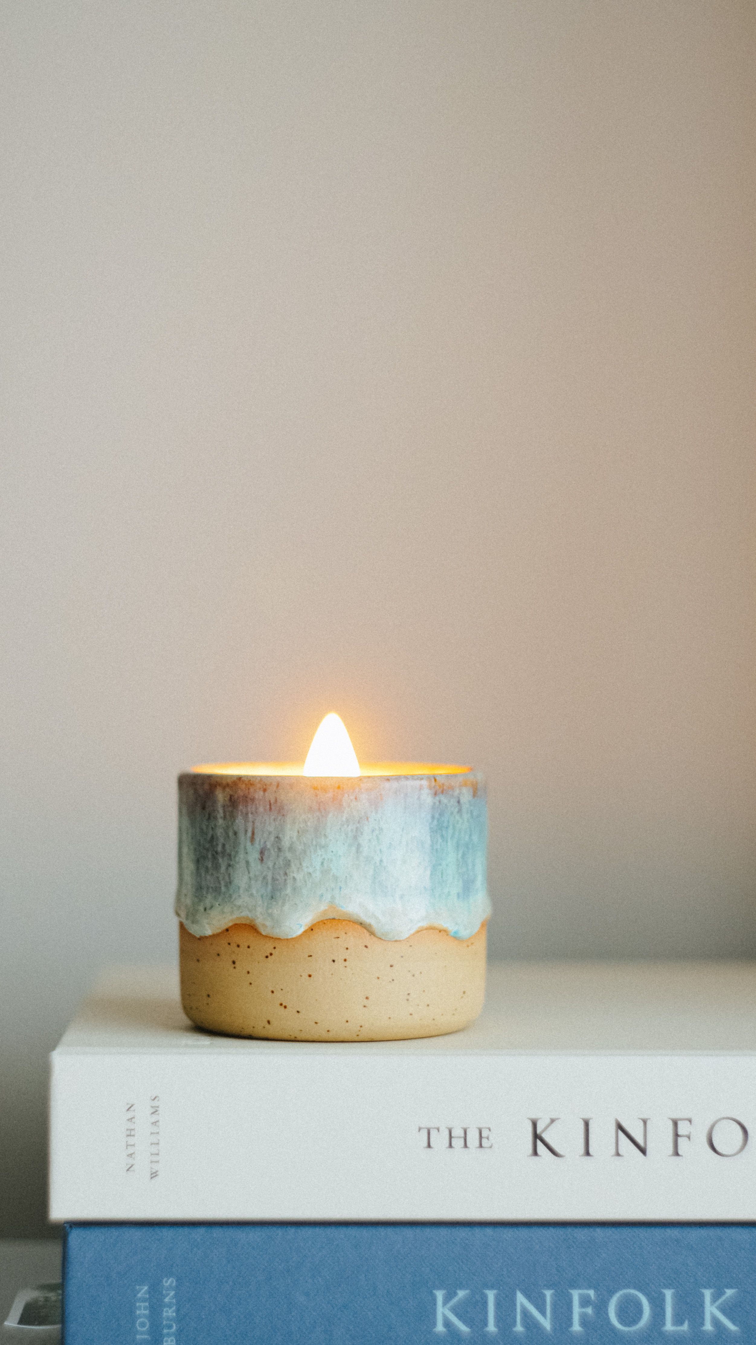 Lit scented candle in a ceramic holder