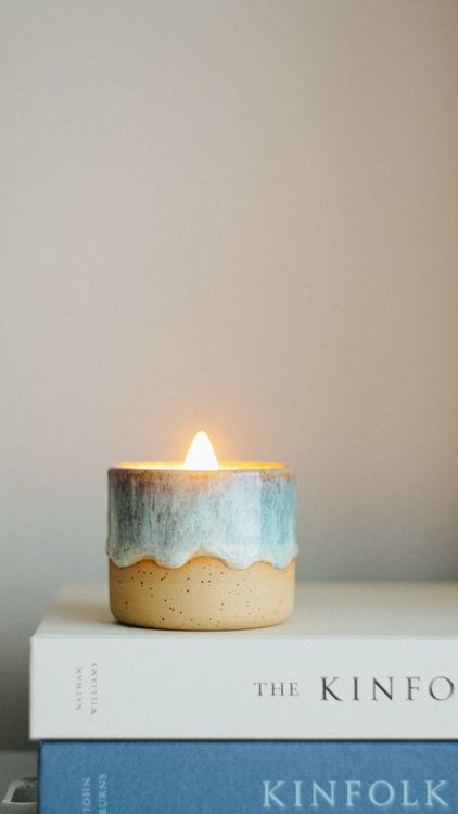 Lit scented candle in a ceramic holder