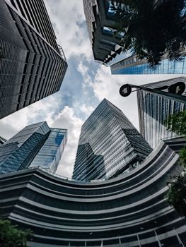 Skyward view of modern skyscrapers with a cloudy sky in Taguig, Philippines.