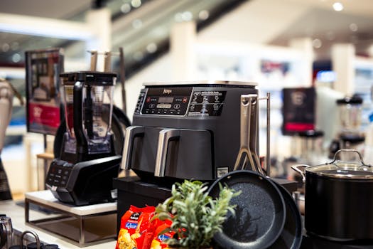 Showcase of modern kitchen appliances in a retail store, featuring blenders and cooking equipment.