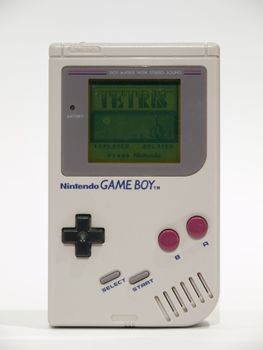 Vintage Nintendo Game Boy with Tetris on screen against a white background.