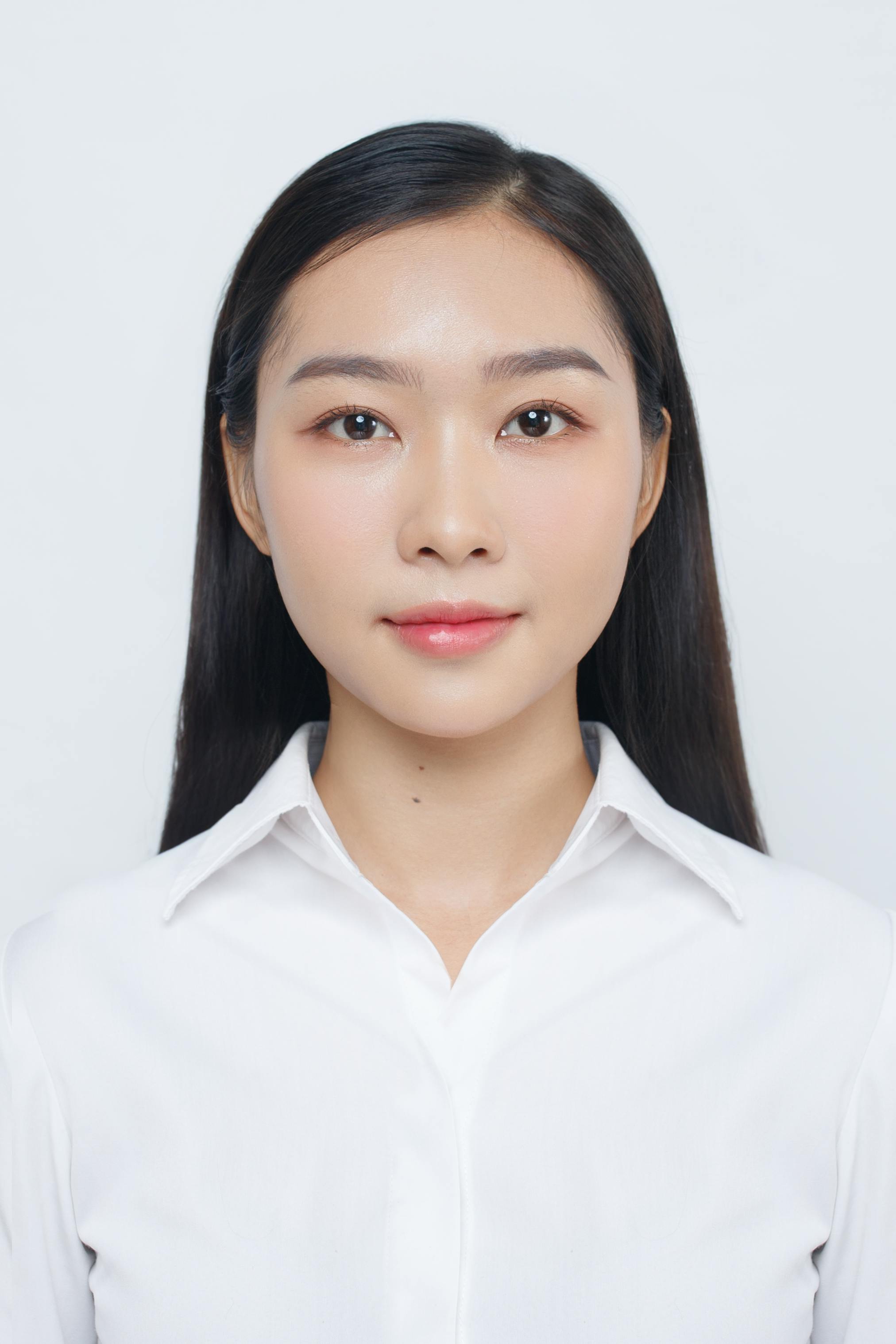 Elegant portrait of a young woman in a white shirt, showcasing professional confidence.
