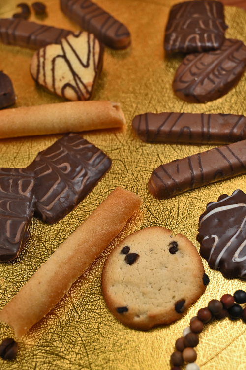 Free A tempting assortment of chocolate cookies and snacks on a golden textured surface. Perfect for sweet cravings. Stock Photo