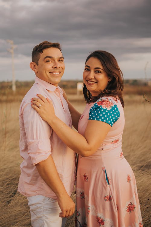 Couple Smiling in Front of a Field