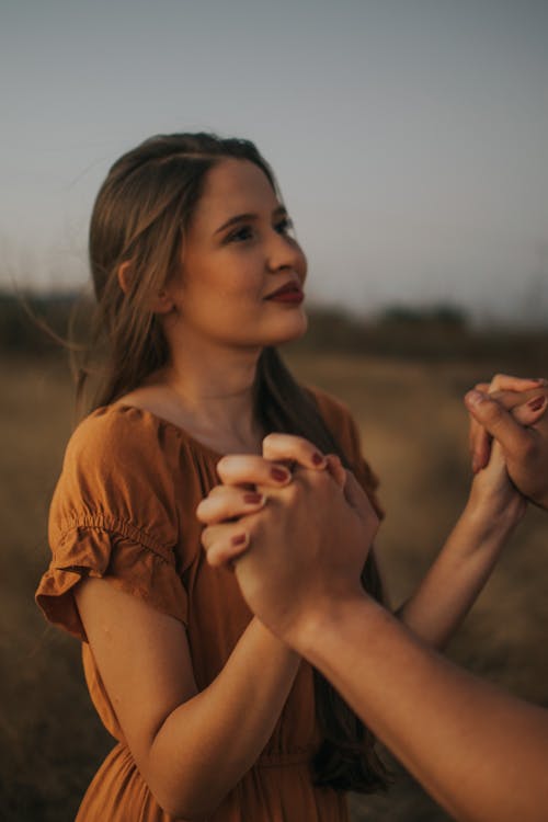 Woman Holding Hands with Man on Meadow