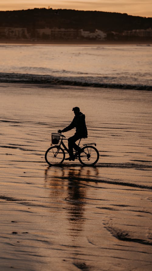 Person Riding a Bicycle Along the Beach