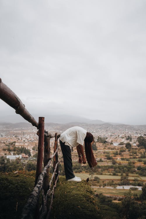 Man Leaning on Hill in Countryside