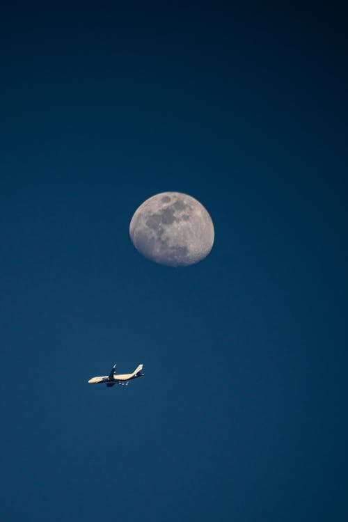 Photo of the Moon and a Flying Airplane 