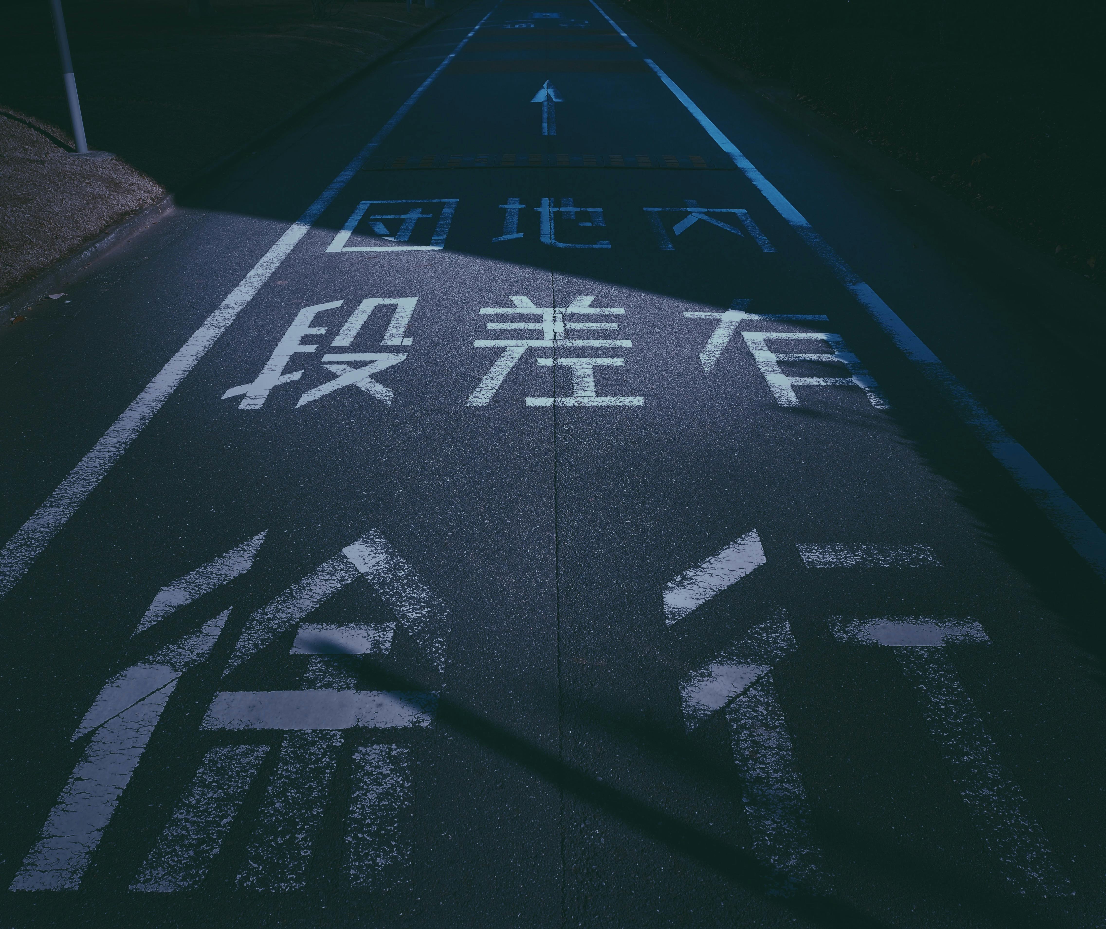 Moody urban Japanese street at night with intriguing road markings.