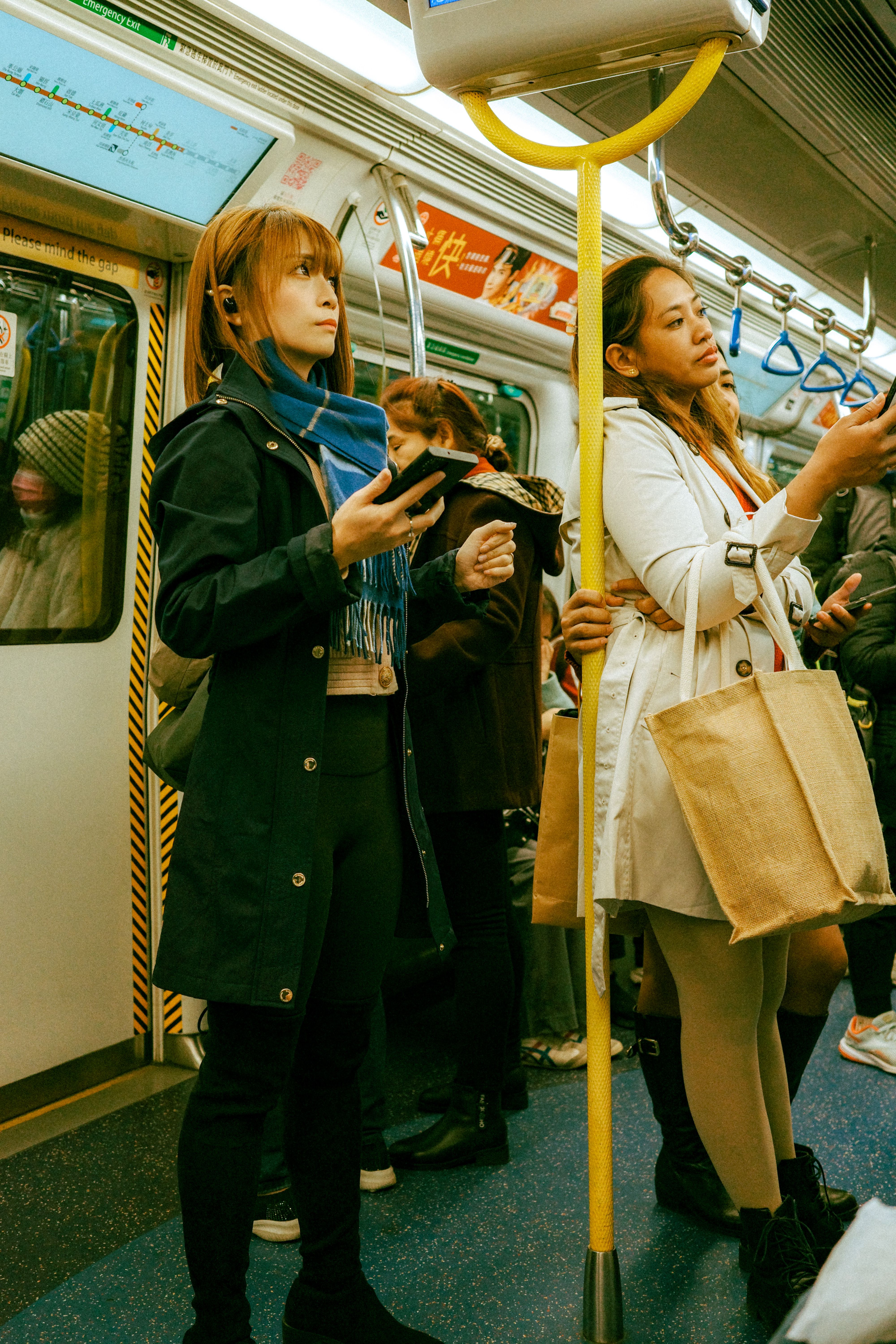 People standing beside a car with bags and phones
