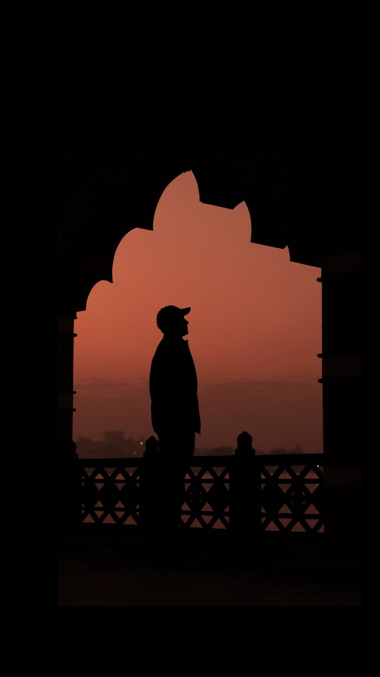 Silhouette Of A Person In A Baseball Cap Looking Up