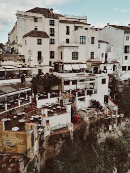 Scenic aerial view of historic buildings and Restaurante Don Miguel on a cliff in Ronda, Spain.