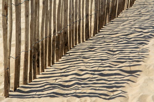 Fence Casting Shadow on Sand