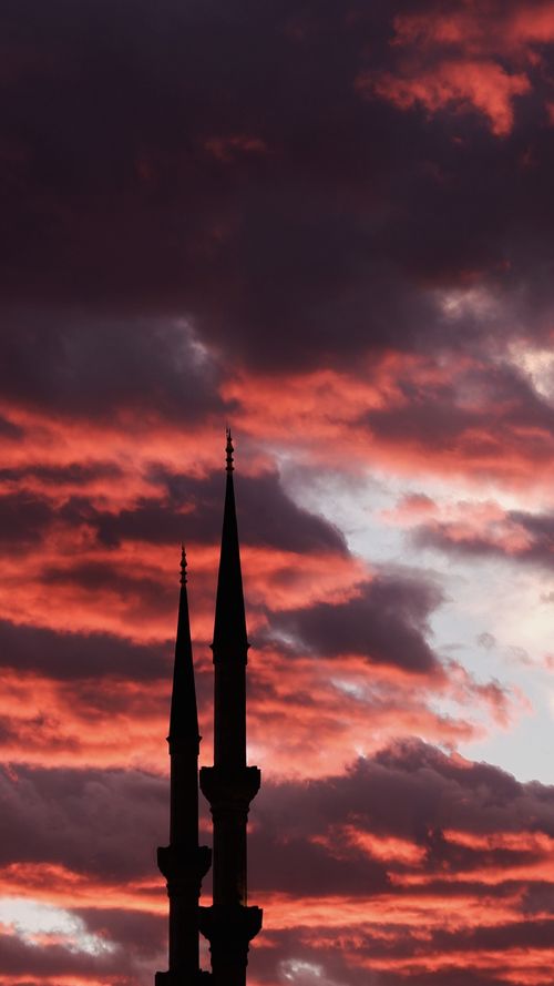 Free Dramatic sunset sky with mosque spires in silhouette, evoking a sense of tranquility and faith. Stock Photo