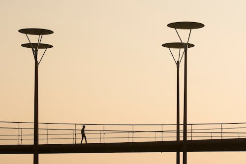 Silhouette of Man on Footbridge