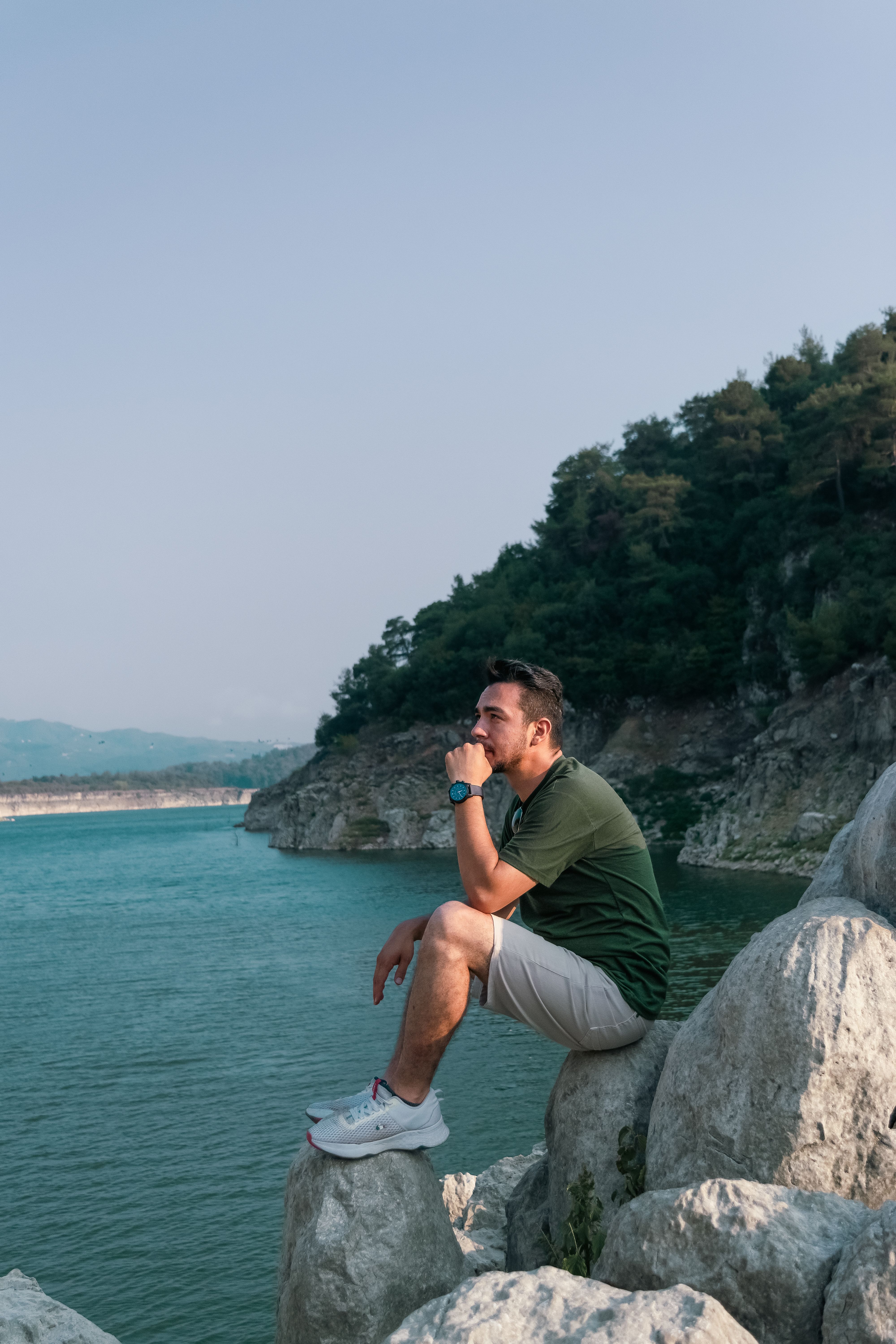 Man Sitting on a Rocky Coast · Free Stock Photo