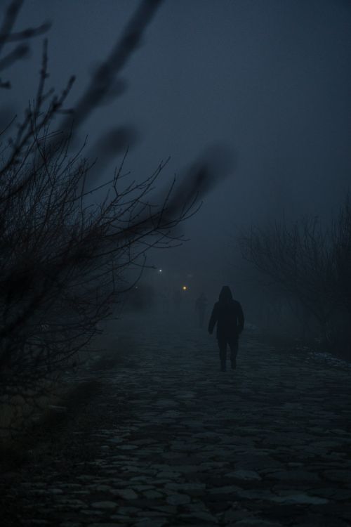 Free A mysterious silhouette walking along a foggy cobblestone path during an eerie twilight in Azerbaijan. Stock Photo