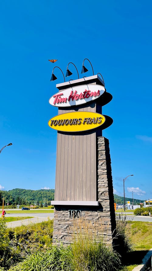 A Tall Tim Hortons Restaurant Sign under Blue Sky 