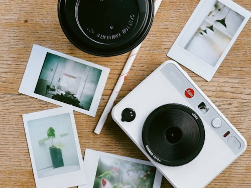 Free A camera, polaroid and polaroid photos on a table Stock Photo