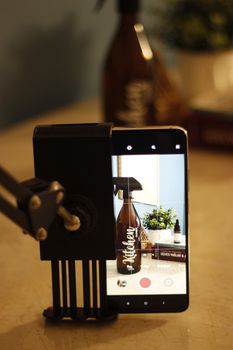 A smartphone on a holder photographing kitchen decor, emphasizing technology in everyday life.