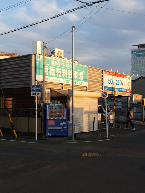 Free Street corner with vending machine and parking signs in Toyohashi, Japan during sunset. Stock Photo