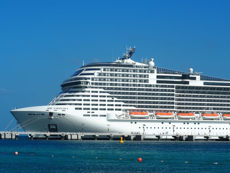 A breathtaking view of the MSC Virtuosa cruise ship docked in a sunny harbor.