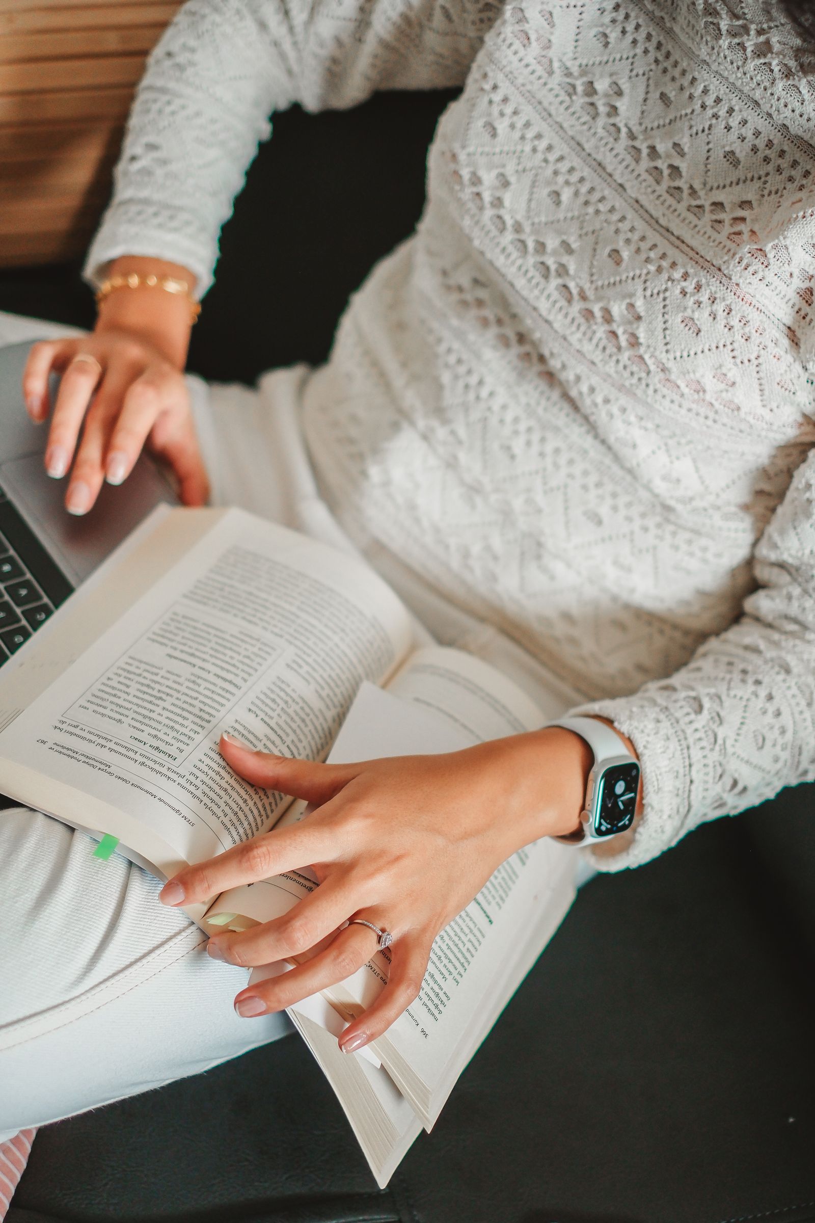 Student using a laptop alongside an open textbook during focused study