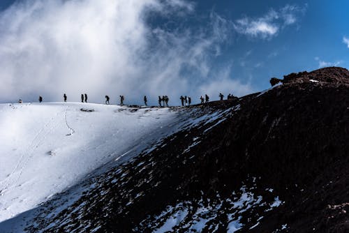 People Hiking on Hill in Mountains in Winter