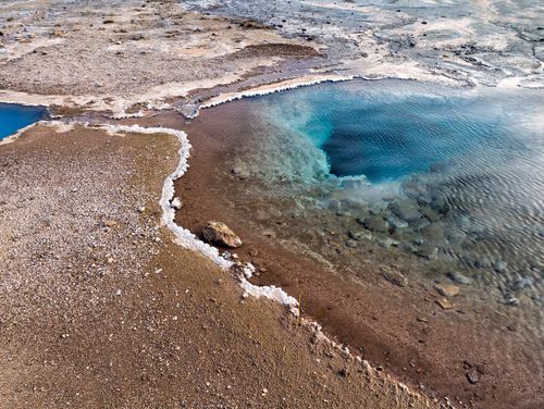 Free Stunning aerial view of a colorful geothermal hot spring in Iceland, showcasing vivid blues and earthy textures. Stock Photo