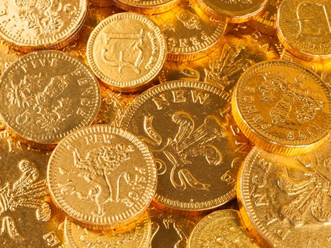 A close-up of gold-colored British pound and pence coins, showcasing intricate details.
