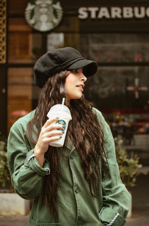 Young Woman with Disposable Cup in Front of Starbucks