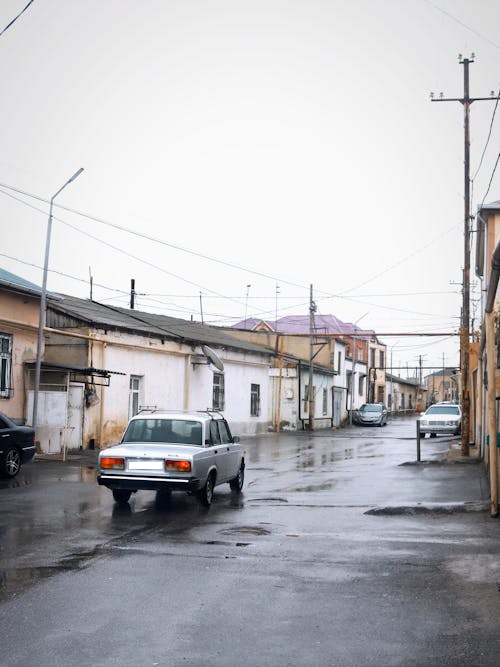 Car on a Street Among House Buildings