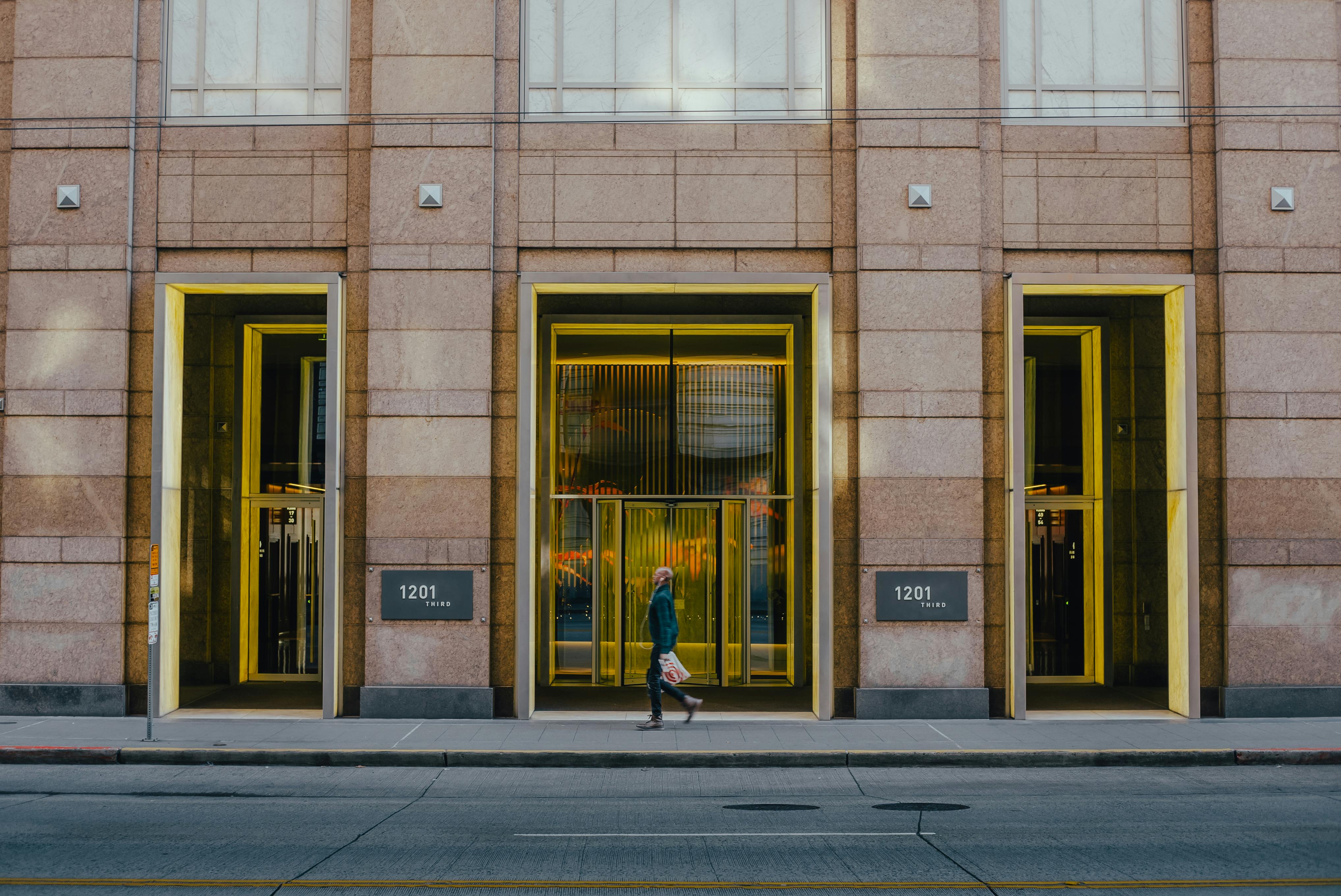 a person walking in front of a building with yellow doors