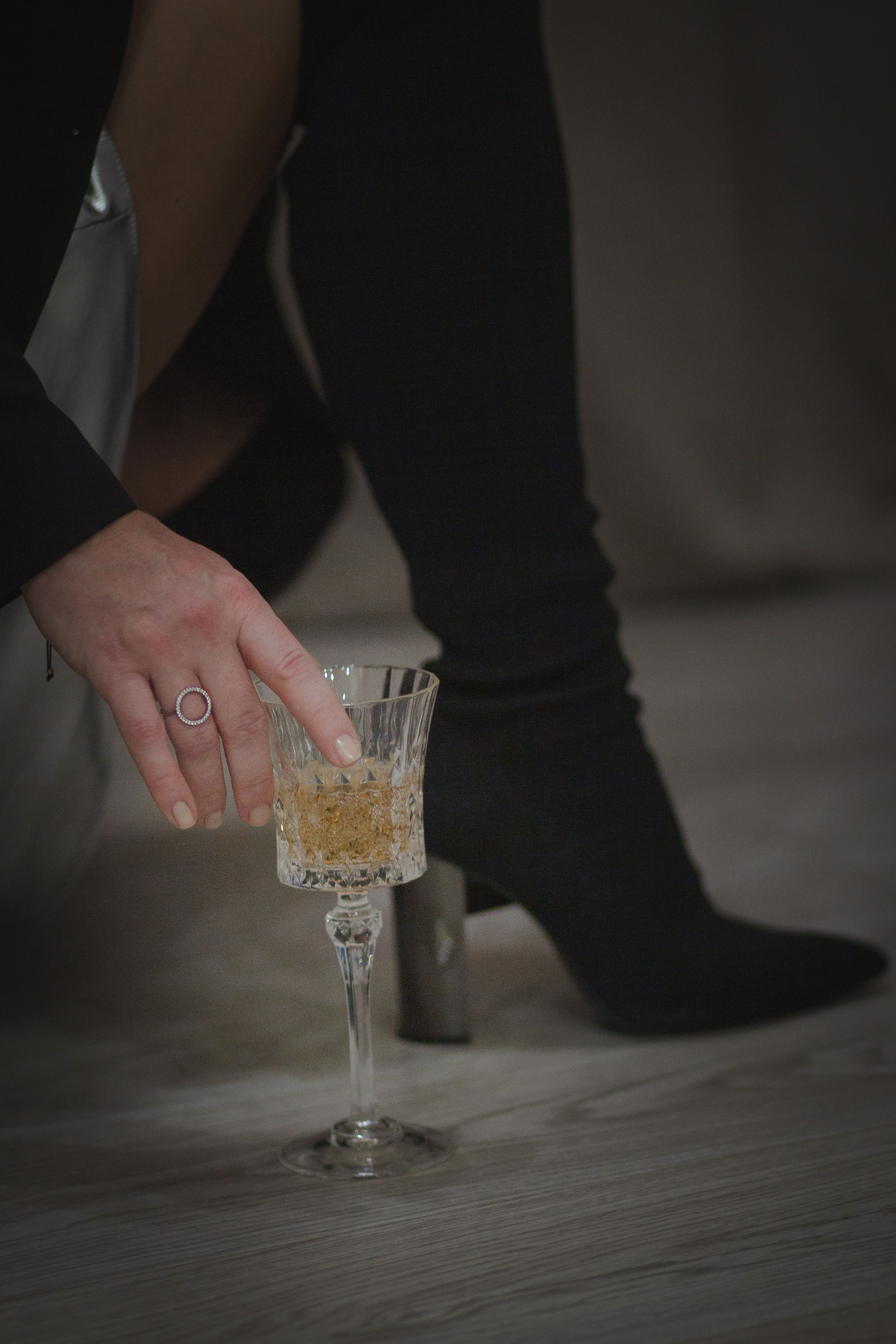 Stylish scene of a woman's hand reaching for a crystal wine glass on a modern floor.