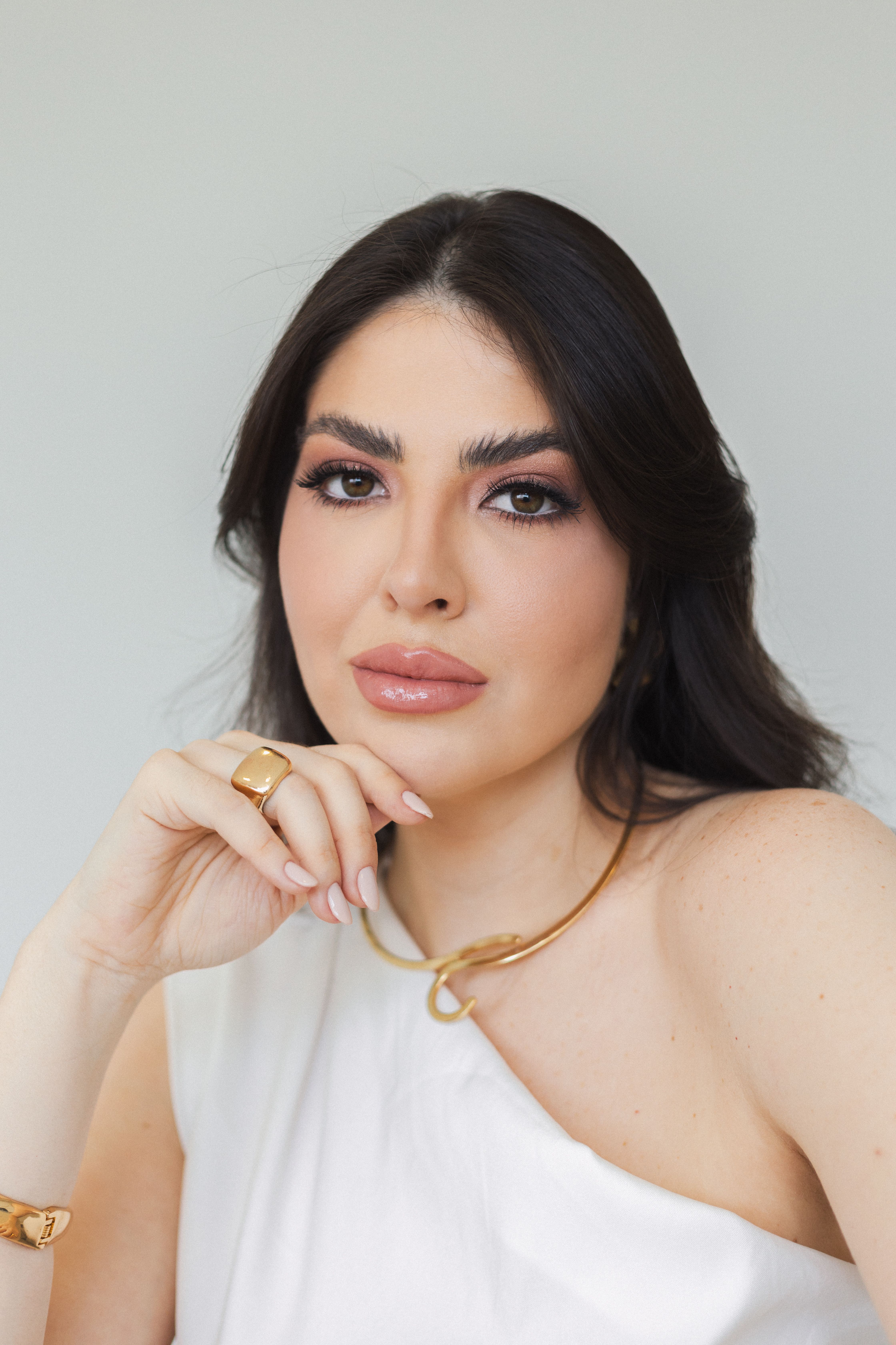 Sophisticated portrait of a woman in studio, showcasing elegance and modern fashion.
