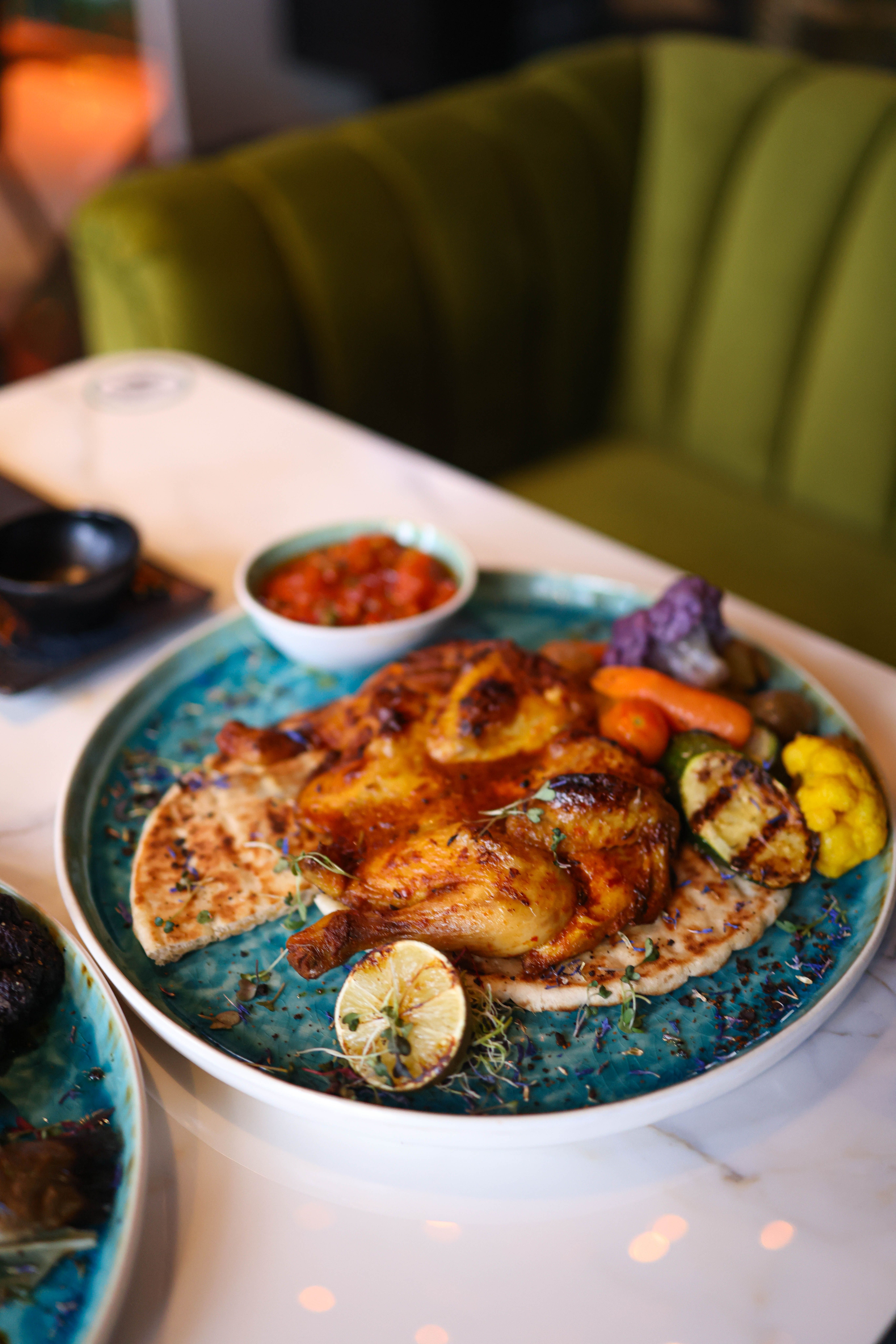 Savor a plate of perfectly roasted chicken with veggies and flatbread, ideal for a delightful dinner.